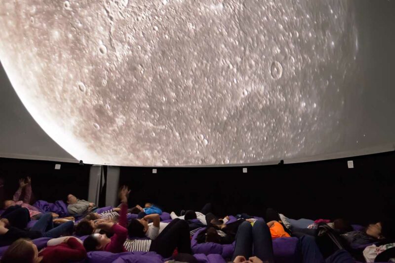 Estudiantes durante la proyección de la película "Explorando el Sistema Solar" en el Planetario de la Casa de la Ciencia de Sevilla.